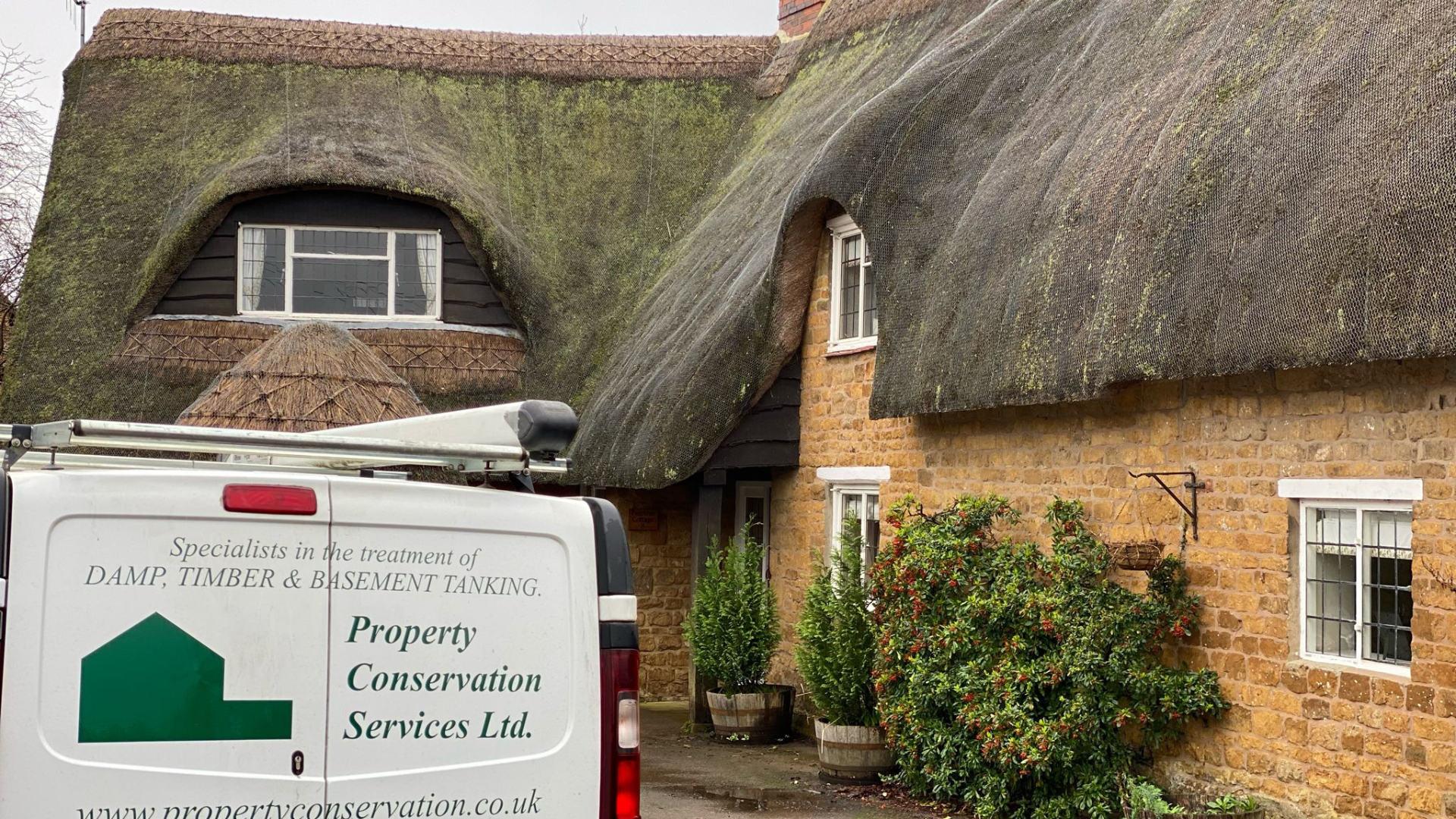The Property Conservation Services van parked in front of the thatched cottage in Upper Tysoe, needing timber treatment for woodworm.
