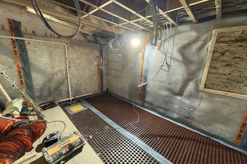Floor membrane and sump pump in situ in the damp basement