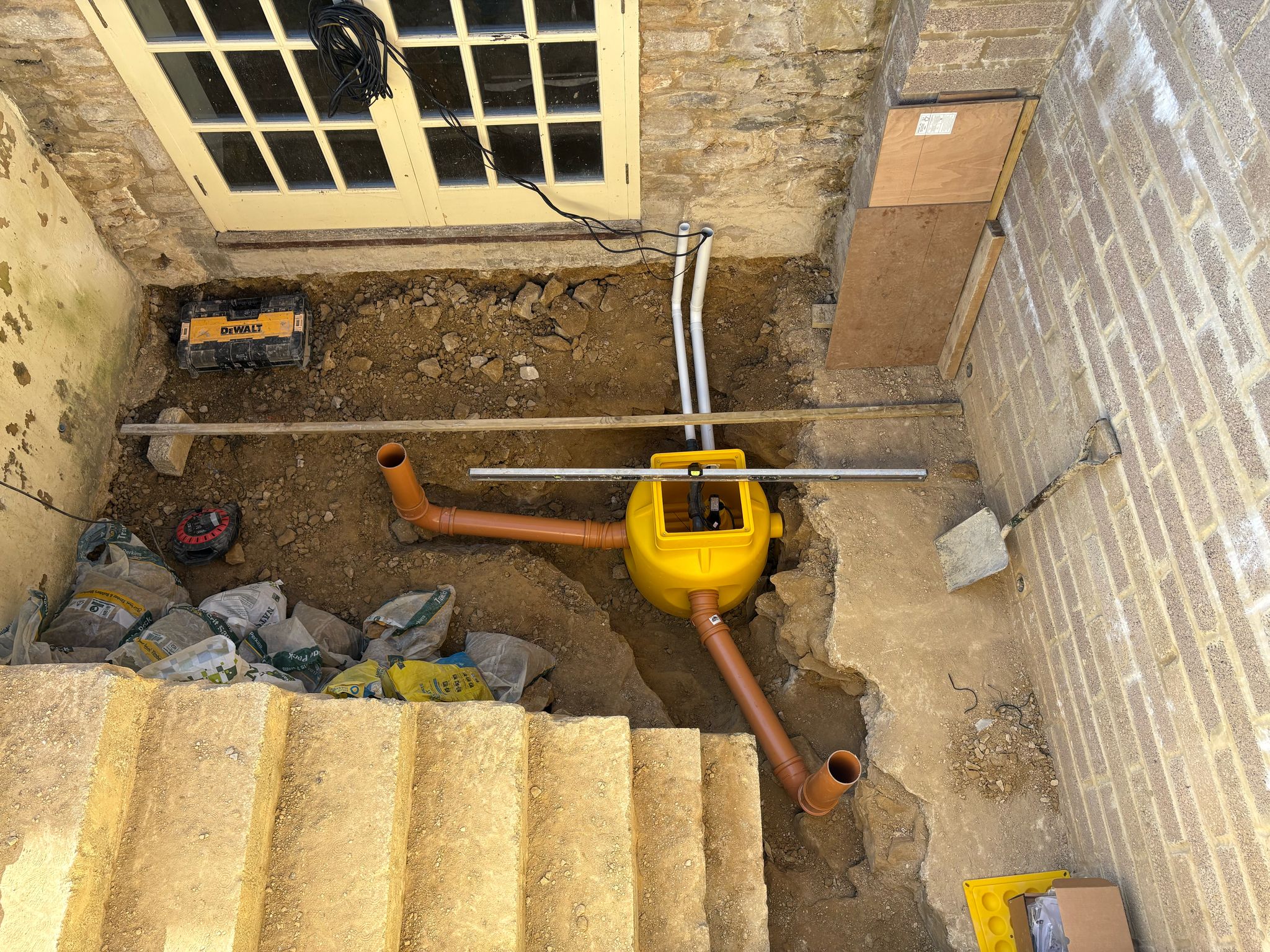 Sump pump in position in the outdoor space about to be converted into a basement for wine storage