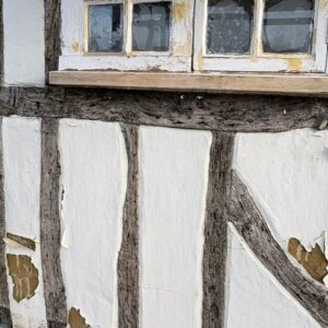 Exterior façade of a listed building where sand and cement render has crumbled off. This was replaced with traditional lime plaster by Property Conservation Services