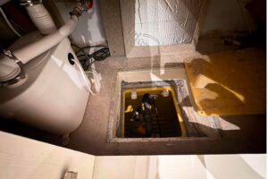A sump pump in a basement conversion, getting a service